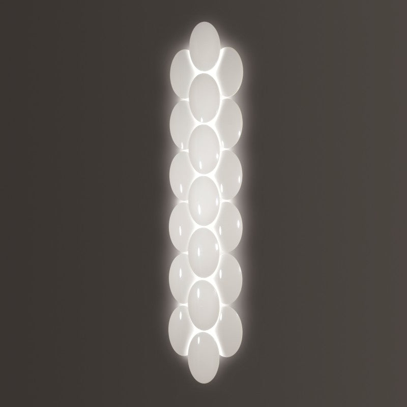 Obolo Wall Light by Zaneen Shop - A white-colored oval shaped lamp with smaller sized ovals that cover the body, together making up its entire shape.