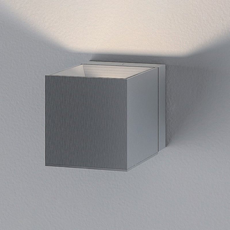 Dau Wall Light by Zaneen Shop - A polished stainless steel cubed-shaped wall fixture with light output at the top.